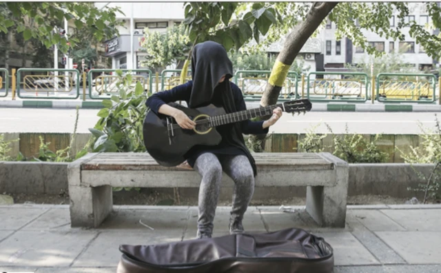 دختری در خیابان در حال ساز زدن