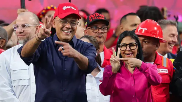 Jorge e Delcy Rodríguez fazem o sinal que supostamente é similar à assinatura de Chávez