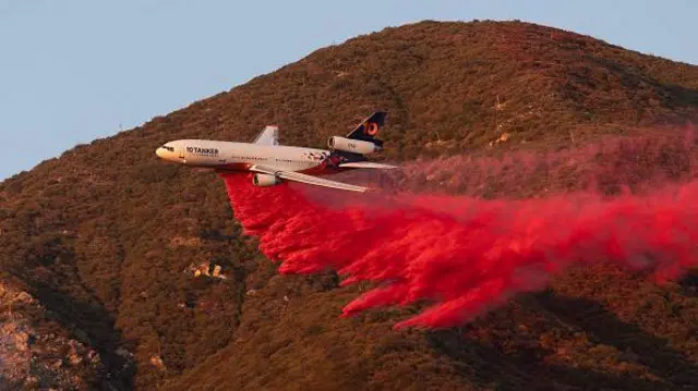 Avião joga pós rosa para apagar fogos de incêndio nos EUA