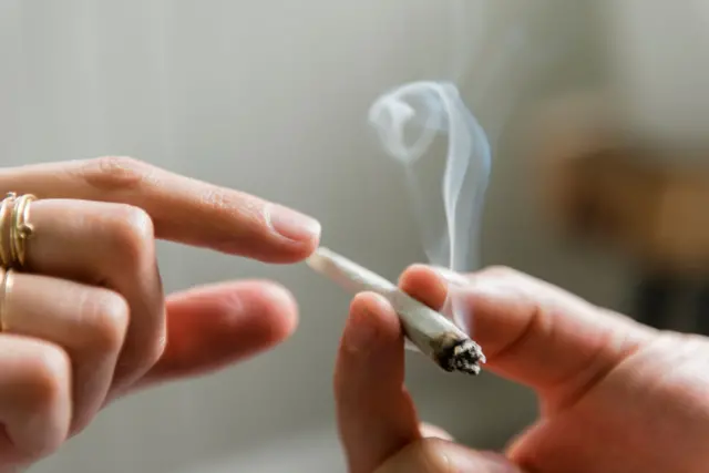 Mãos femininas passando um cigarrolampions bet login entrarmaconha.