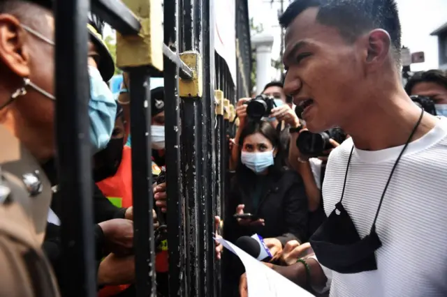 Anti-government protester Panupong Mike Jadnok confronts a policeman at the Ministry of Finance as demonstrators denounced Prime Minister Prayut Chan-O-Cha for allegedly neglecting to provide economic aid for the Thai people during the Covi-19 coronavirus epidemic in Bangkok on January 22, 2021. 