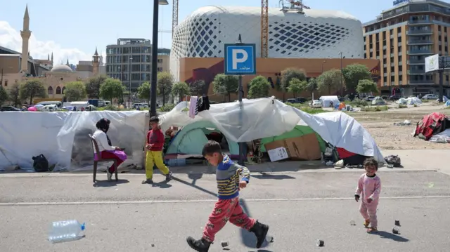 在黎巴嫩贝鲁特,流离失所的儿童在临时营地的帐篷旁玩耍。