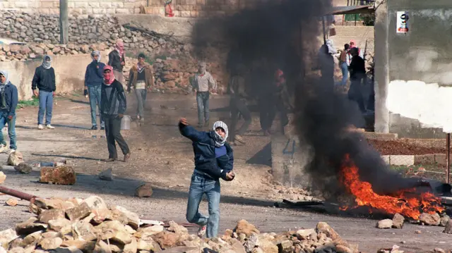 Manifestante palestino jogando pedra