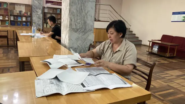 Гүлзада Абдалиева архивден алып келген материалдар менен тааныштырып жатат