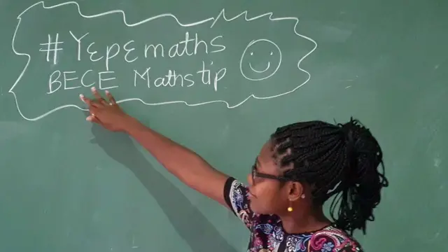 Dr Angela Tabiri regarde vers un tableau noir sur lequel sont écrits à la craie des conseils de mathématiques lors d'une leçon de FemAfricMaths sur YouTube pour des élèves de collège.
