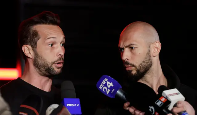 Andrew Tate e seu irmão Tristan (à esquerda) falam com repórteres de TV após retornar de uma viagem aos Estados Unidos, em março de 2025