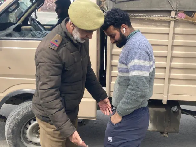 आम लोगों की जांच करते सुरक्षाकर्मी