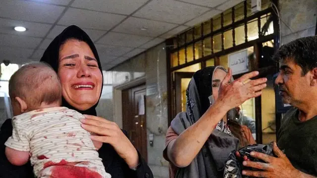 Una madre y su bebé con sangre en la ropa