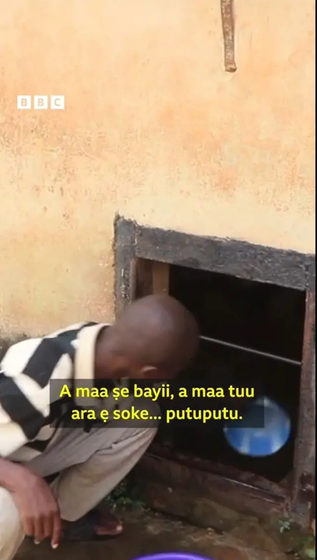 Ọkunrin kan n fi ike bu omi lati oju ferese