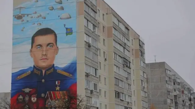  Каза болгондордун айрымдарынын сүрөттөрү жашаган үйлөрүнүн дубалдарында илинип турат