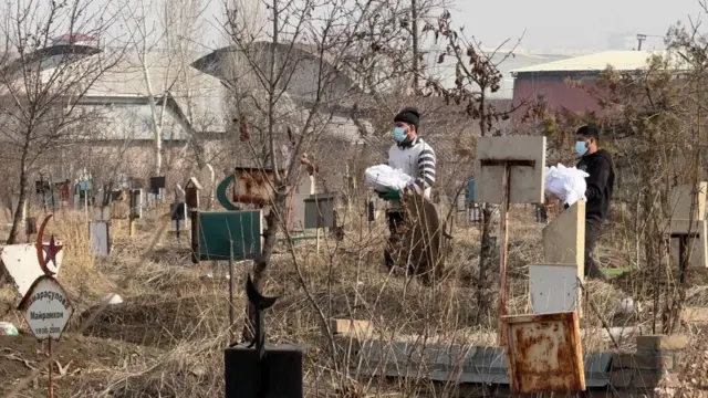 Тургундар көрүстөндөгү жакындарынын сөөгүн мүрзөнүн ичкери тарабына көчүрүп жатышат.