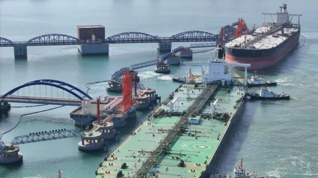 Sebuah kapal tanker minyak yang sangat besar dibantu oleh kapal tunda saat berlabuh di terminal minyak mentah Pelabuhan Yantai seberat 300.000 ton di Yantai, Provinsi Shandong, China pada 25 April 2024.