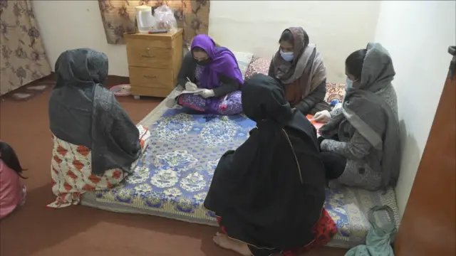 The outreach workers are having a chat with sex workers at a brothel in Lahore