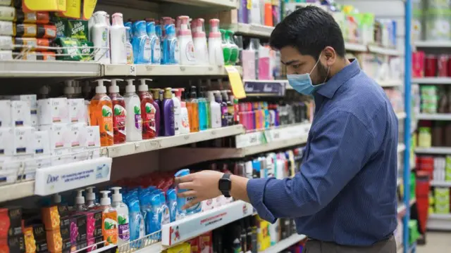 মুখে মাস্ক পরে বাজার করছেন এক লোক 