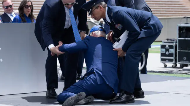 Joe Biden is helped up after falling during the graduation ceremony at the United States Air Force Academy