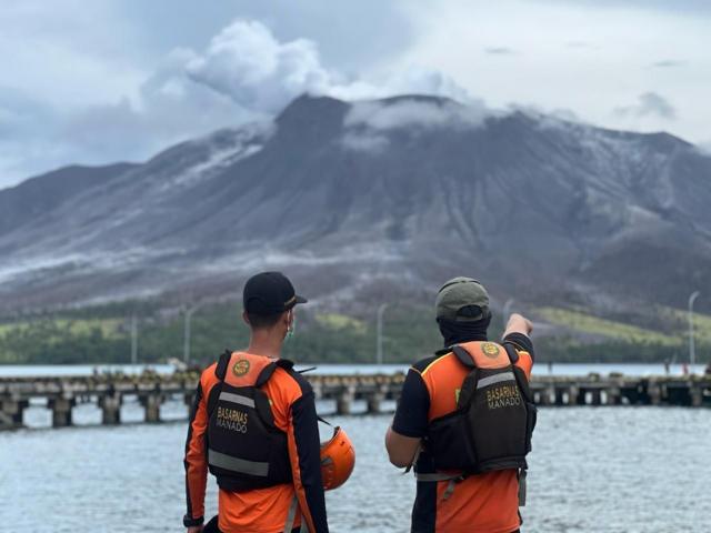 Dos personas miran el monte Ruang en erupción