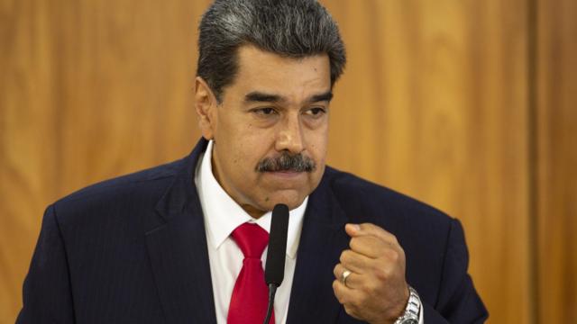 O presidente da Venezuela, Nicolás Maduro. Ele usa terno escuro, camisa branca e gravata vermelha. No pulso, usa um relógio prateado
