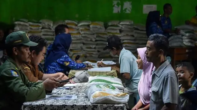 Petugas mengecek data warga penerima saat penyaluran Bantuan Sosial (Bansos) Cadangan Beras Pemerintah (CBP) di Desa Manonjaya, Kabupaten Tasikmalaya, Jawa Barat, Senin (19/2/2024). 