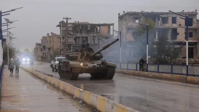 يجلس أفراد عسكريون فوق دبابة، بعد انسحاب قوات سوريا الديمقراطية من محافظة دير الزور وسيطرة الجيش السوري الكاملة على المنطقة، في دير الزور، سوريا.