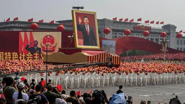 2019 年 10 月 1 日，在北京天安門廣場舉行的慶祝中華人民共和國成立 70 週年閱兵式上，中國國家主席習近平的巨幅畫像被放置在一輛彩車上