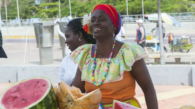 Mujer en Cartagena con vestido tradicional vendiendo sandía y otras frutas