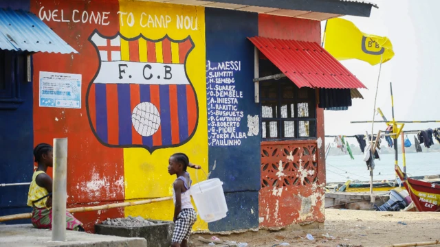 CYara tsaye gaban ginin da akai wa ado da tambarin kungiyar Barcelona a garin Fanti da ke kusa da wurin wasa na Robertsport a Grand Cape Mount County, da ke Liberia - ranar Asabar 20 Maris 2021