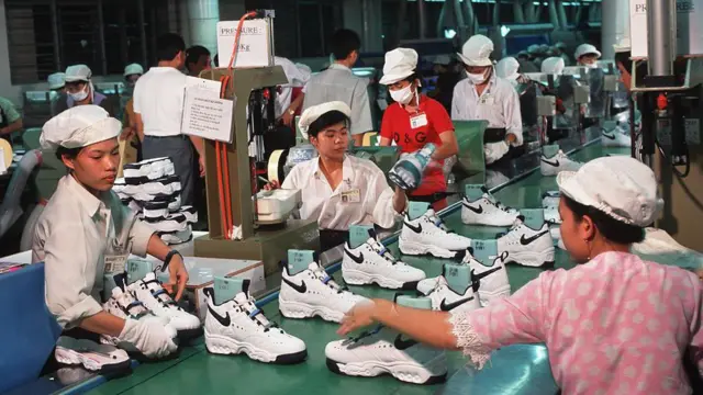 Pekerja di pabrik Nike dekat Kota Ho Chi Minh sedang merakit sepatu olahraga Nike.