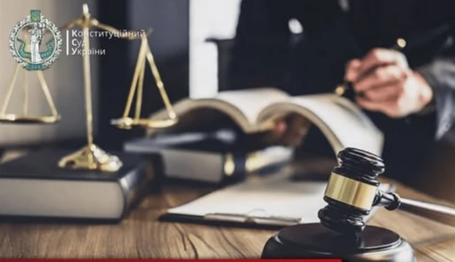 Суддя за столом, з атрибутами правосуддя 