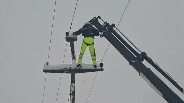 radnik popravlja dalekovod