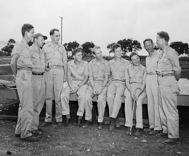 Grupo de científicos estadounidenses que eran jefes de grupo encargados del montaje, la investigación y la inspección de las bombas atómicas en una base de las islas Marianas. De izquierda a derecha: Norman Ramse, Roger S. Warner , Edward B. Doll, Harold Agnew, Luis W. Alvarez, Lawrence Johnston, Philip Morrison, Robert Serber y Bernard Waldman.