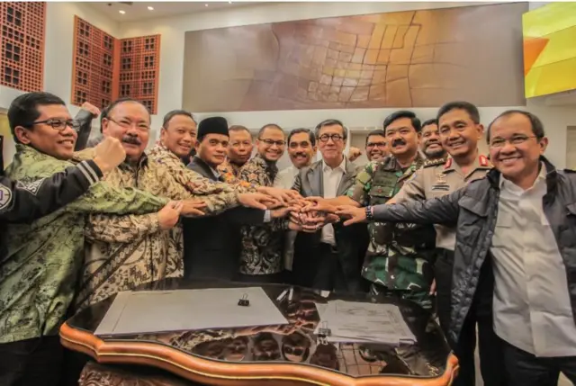 Sehari sebelum pengesahan, pemerintah dan DPR mencapai kesepakatan tentang definisi terorisme, yang sebelumnya dianggap jadi penghalang pengesahan. Usai kesepakatan, Menkumham Yasonna Laoly (keenam kanan) berjabat tangan bersama Ketua Pansus Terorisme Muhammad Syafii (keempat kiri), Panglima TNI Marsekal Hadi Tjahjanto (ketiga kanan), Irwasum Polri Komjen Pol Putut Eko Bayuseno (kedua kanan), Kepala BNPT Komjen Pol Suhardi Alius (ketujuh kiri) dan Anggota Pansus Terorisme DPR lainnya.