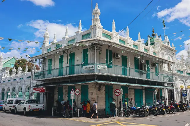 Groupe de personnes debout à l’extérieur d’un bâtiment dans la ville de Port-Louis, île Maurice