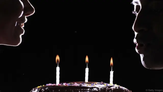 생일 케이크를 앞에 두고 있는 두 사람