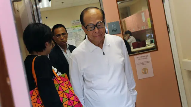 身穿白色上衣的李嘉誠(中)到香港瑪麗醫院探望南丫海難中獲救的港燈員工與家屬後離開病房,神情凝重,長子李澤鉅(左二)緊隨其後(2/10/2012)