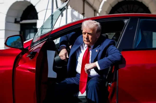 Trump saliendo de un Tesla rojo