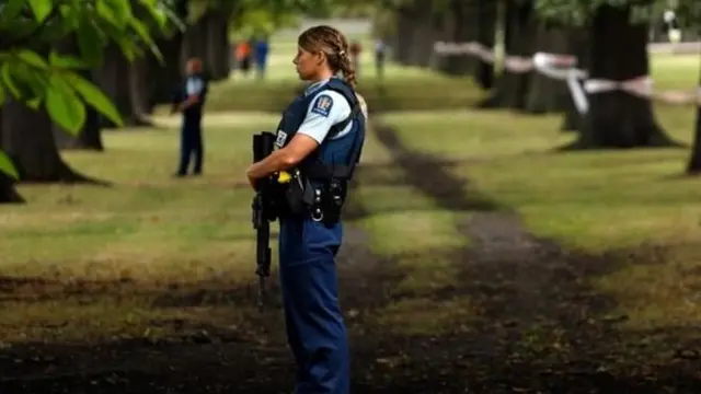 Police officers stand guard near the scene of the deadly shooting in New Zealand