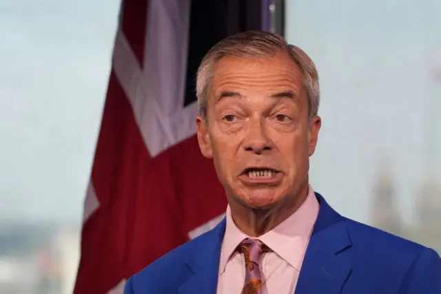 Nigel Farage İngiltere bayrağının önünde konuşurken.