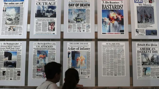 Pessoas olhando capas de diferentes jornais