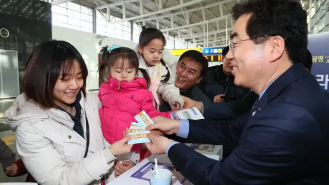 광명역 광명-파리행 가상열차표 예매소에서 한 가족이 파리행 가상 티켓을 받고 있다