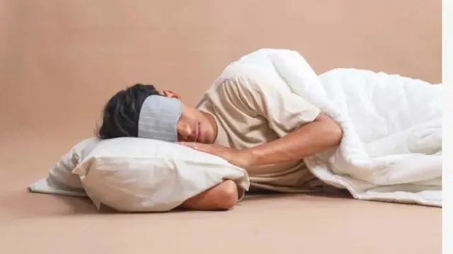 Aworan ẹni to fi ẹgbẹ sun, o rọri o si fi aṣọ bo ojuu rẹ.