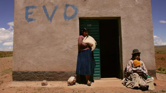 Dos mujeres frente a una vivienda
