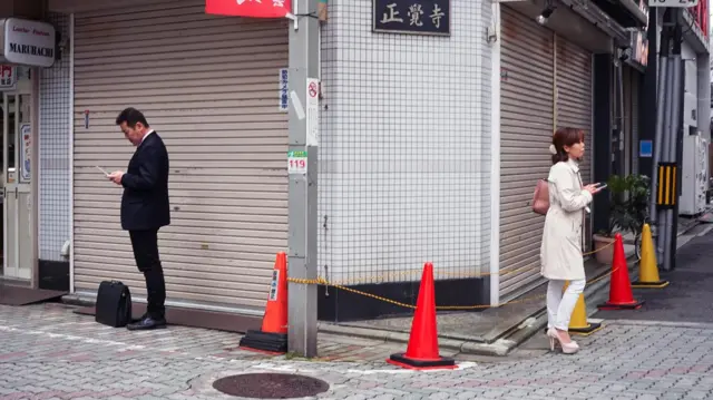 Deux personnes dos à dos dans la rue.