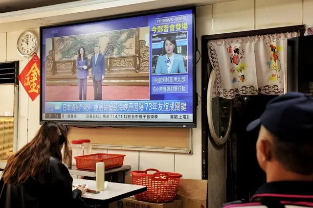 電視畫面顯示台灣在野黨國民黨主席鄭麗文於 2026 年 4 月 10 日在北京與中國國家主席習近平會面的場景，拍攝地點是台北一家餐廳。