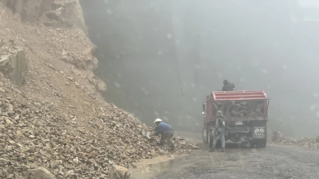 Hombres recogen piedras de un deslave