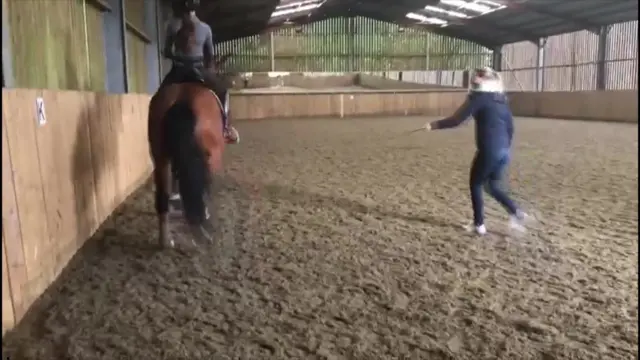 Charlotte Dujardin usando un fuete con un caballo