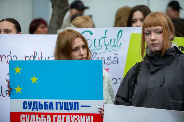 Две молодые женщины на митинге в поддержку Гуцул, у одной в руках плакат с надпись. «Судьба Гуцул — судьба Гагаузии»
