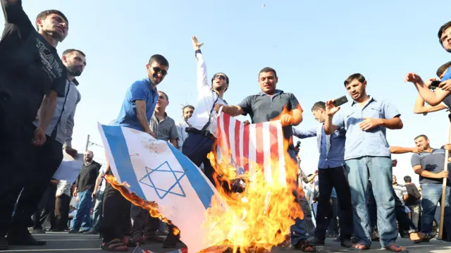 Молодые люди на площади в Нардаране сжигают флаги Израиля и США в 2015 году.