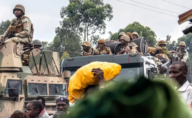 Ku ifoto yo muri Gashyantare(2) 2024, abasirikare b’ingabo za SADC bari kugenda mu modoka mu mujyi wa Goma iruhande rw’abantu barimo bahunga imirwano y’i Sake muri teritwari ya Masisi