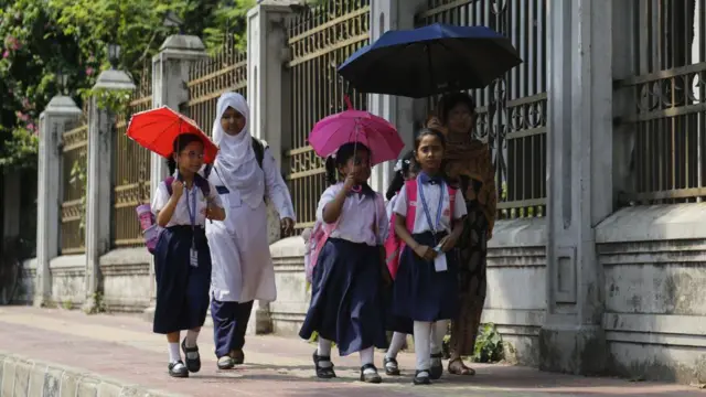 শিক্ষার্থীরা ছাতা মাথায় হেঁটে যাচ্ছে