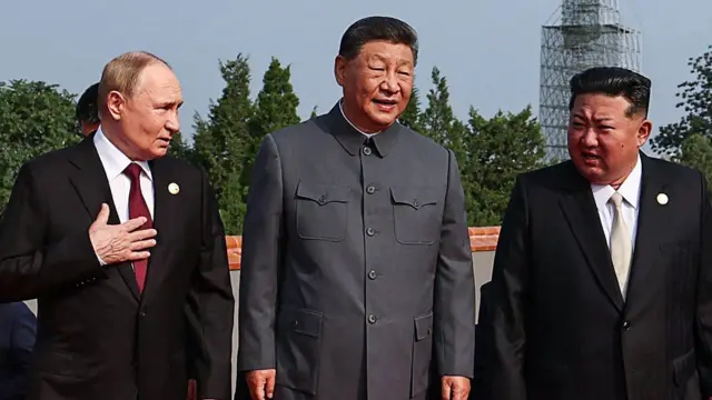 (من اليسار إلى اليمين) الرئيس الروسي فلاديمير بوتين يسير مع الرئيس الصيني شي جين بينغ وزعيم كوريا الشمالية كيم جونغ أون